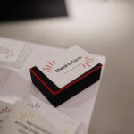 Bunt gemischte Check-in Cards mit deutschen Gesprächsfragen liegen offen auf einem Tisch.