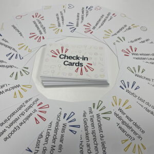 Check-in Cards mit farbigen Symbolen und Gesprächsfragen, aufgefächert um einen Kartenstapel mit Logo.